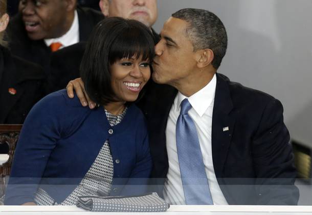 President Barack Obama kisses first lady Michelle Obama in the presidential box near the White House, Monday, Jan. 21, 2013, in Washington. Thousands marched during the 57th Presidential Inauguration parade after the ceremonial swearing-in of President Barack Obama.