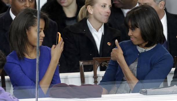 First lady Michelle Obama poses for photographs for her daughter Malia during the inaugural parade Monday, Jan. 21, 2013, in Washington. Thousands marched during the 57th Presidential Inauguration parade after the ceremonial swearing-in of President Barack Obama.