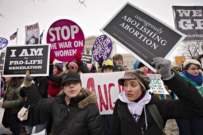 Anti-abortion activists and supporters of legal abortion stand in front of the Supreme Court in Washington, Friday, Jan. 25, 2013, on the 40th anniversary of the Roe v. Wade decision. Thousands of anti-abortion demonstrators marched through Washington to the steps of the U.S. Supreme Court to protest the landmark decision that legalized abortion.