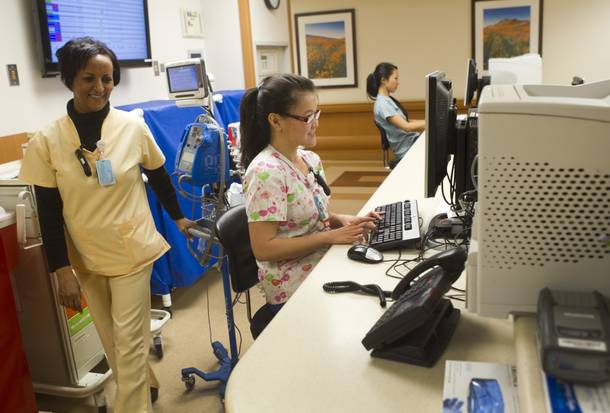 Nurse Tristan Tran, center, works at a nurse's station at Sunrise Hospital Monday, March 25, 2013. Also pictured are nurse's assistant Ghennet Haile, left, and Cristiana Saito, a physical therapy student.