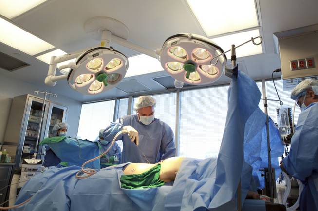 Dr. Kaveh Alizadeh, the president of Long Island Plastic Surgical Group, performs a buttocks lift on a patient at his clinic in Garden City, New York, Feb. 10, 2011. As the demand for surgical enhancement explodes around the world, New York has developed a host of niche markets that allow the city's many immigrants to get tucks and tweaks that are carefully tailored to their cultural preferences and ideals of beauty.