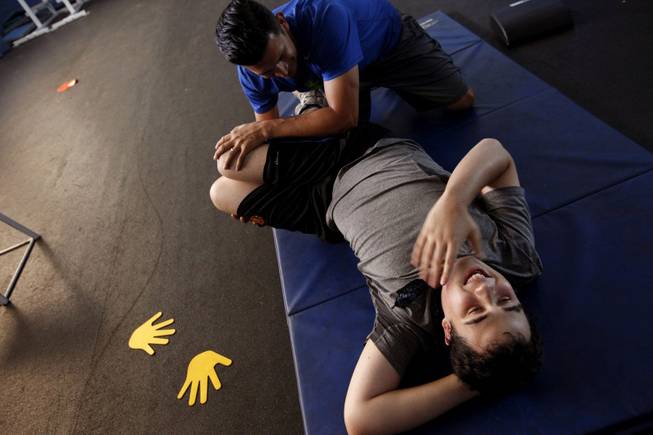 Ido Kedar, who is a non-verbal autistic teenager, works out with special fitness instructor Mike Ramirez at a local high school in West Hills, Calif., on Nov. 4, 2013. Kedar doesn't play sports, but his parents try to keep him in shape by working out with Ramirez. He is also the author of the book, "Ido in Autismland - Climbing Out of Autism's Silent Prison," which was published in 2012.