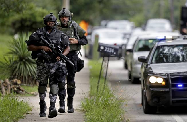 Dekalb County Police SWAT officers run toward Ronald E. McNair Discovery Learning Academy after reports of a gunman entered the school, Tuesday, Aug. 20, 2013, in Decatur, Ga. Superintendent Michael Thurmond says all students at Ronald E. McNair Discovery Learning Academy in Decatur east of Atlanta are accounted for and safe Tuesday and that he is not aware of any injuries. (AP Photo/David Goldman)
