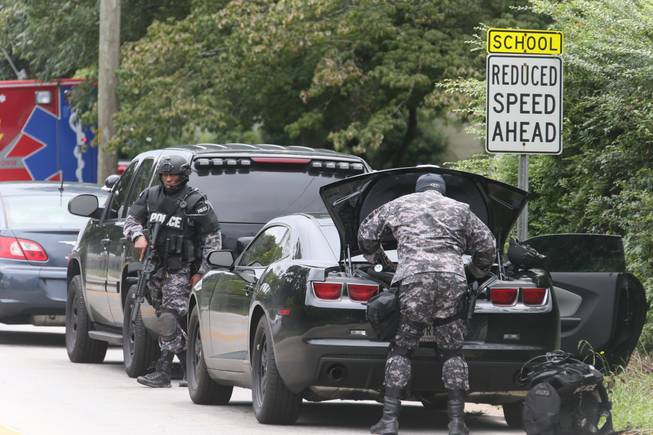 Dekalb County Police SWAT officers prepare at Ronald E. McNair Discovery Learning Academy after reports of a gunman entered the school, Tuesday, Aug. 20, 2013, in Decatur, Ga. A suspect was in custody after reports of gunfire at an Atlanta-area elementary school Tuesday, the school chief said, with television footage showing young students running out the school being escorted by teachers and police. Michael Thurmond told The Associated Press he had no reports of injuries and that all students and teachers are accounted for and safe. (AP Photo/Atlanta Journal-Constitution, Bob Andres)