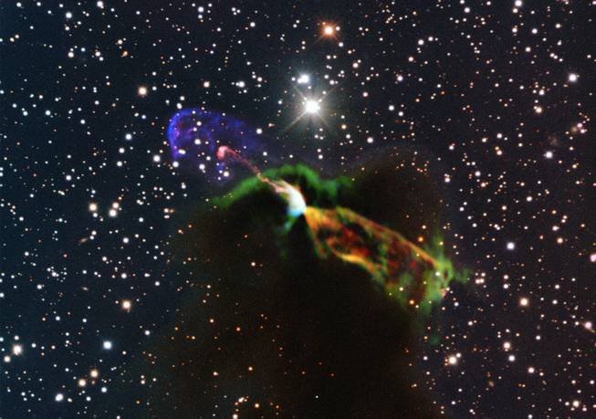 This image made available by the European Southern Observatory on Tuesday, Aug. 20, 2013, using radio and visible light frequencies shows the Herbig-Haro object HH 46/47. The orange and green, lower right, of the newborn star reveal a large energetic jet moving away from the Earth, which in the visible is hidden by dust and gas. To the left, in pink and purple, the visible part of the jet is seen, streaming partly towards the Earth. Astronomers say these illuminated jets from the newborn star are spewing out faster than ever measured before and are more energetic than previously thought.