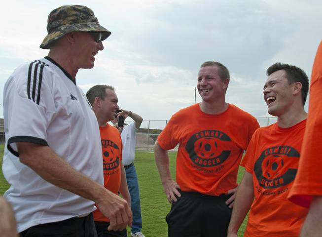 Chaparral High alumnus Brian Bintz, center, and Cody Okuda, right, of the class of 1994, reminisce with former Cowboy head coach Randy Minigal, left, about winning the State title in 1993 after participating in a game against current Chaparral players at the school on Saturday morning.