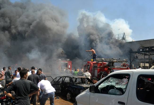 Lebanese citizens gather at the site of an explosion outside of a mosque in the northern city of Tripoli, Lebanon, Friday Aug. 23, 2013. Lebanon's official news agency says dozens of people have been killed by twin explosions outside two Sunni mosques in a northern city. The explosions in Tripoli come amid rising tensions in Lebanon resulting from Syria's civil war, which has sharply polarized the country along sectarian lines and between supporters and opponents of the regime of President Bashar Assad. Tripoli has previously seen clashes between Sunnis and Alawites, a Shiite offshoot sect to which Assad belongs.(
