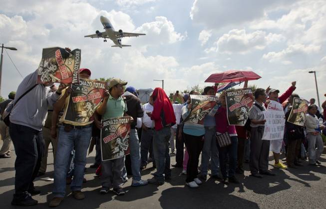 Teachers protest near the Benito Juarez International Airport in Mexico City, Friday, Aug. 23, 2013. Thousands of striking teachers strangled traffic and blocked access to Mexico City's international airport on Friday, flexing their muscles in a bid to block educational reforms intended to introduce teacher evaluations and reduce union power over hiring decisions.