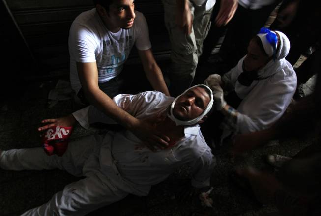 A wounded Egyptian man receives treatment on the ground during clashes between security forces and supporters of Egypt's ousted President Mohammed Morsi in Ramses Square, near the Al-Fath mosque, in downtown Cairo, Egypt, Friday, Aug. 16, 2013. Gunfire rang out over a main Cairo overpass and police fired tear gas as clashes broke out after tens of thousands of Muslim Brotherhood supporters took to the streets Friday across Egypt in defiance of a military-imposed state of emergency following the country's bloodshed earlier this week.