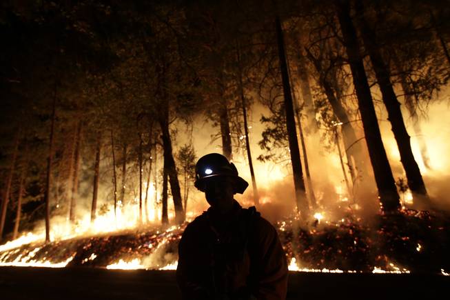 A firefighter watches for spot fires during a burnout operation while battling the Rim Fire near Yosemite National Park, Calif., on Sunday, Aug. 25, 2013. Fire crews are clearing brush and setting sprinklers to protect two groves of giant sequoias as a massive week-old wildfire rages along the remote northwest edge of Yosemite National Park.