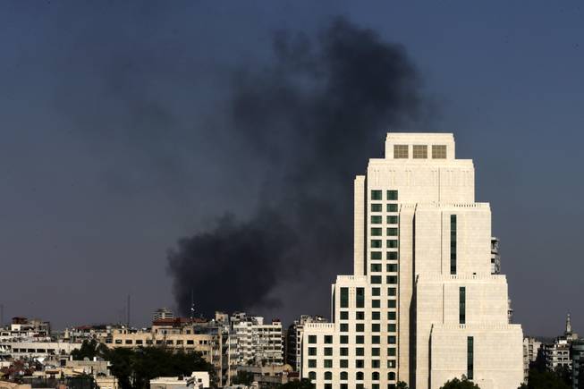Black columns of smoke rise from heavy shelling in the Jobar neighborhood in East of Damascus, Syria, on Sunday, Aug. 25, 2013. Syria reached an agreement with the United Nations on Sunday to allow a U.N. team of experts to visit the site of alleged chemical weapons attacks last week outside Damascus, state media said.