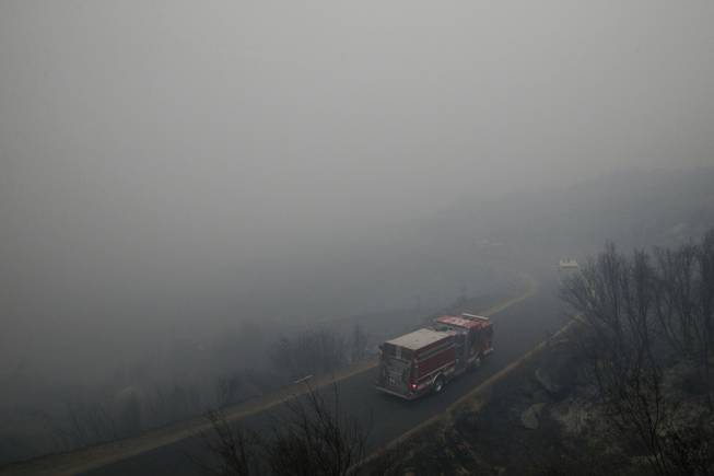 Fire trucks drive through heavy smoke generated by the Rim Fire near Yosemite National Park, Calif., on Tuesday, Aug. 27, 2013. Firefighters gained some ground Tuesday against the huge wildfire burning forest lands in the western Sierra Nevada, including parts of Yosemite National Park.