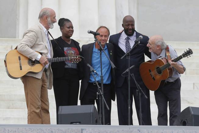 With Trayvon Martin parents, Sybrina Fulton, and Tracy Martin, Peter Yarrow, far right, and Paul Stookey, far left, of the folk trio Peter, Paul and Mary, perform at the 50th Anniversary of the March on Washington where Martin Luther King, Jr., spoke, Wednesday, Aug. 28, 2013, in front of the Lincoln Memorial in Washington. Man at center is unidentified.