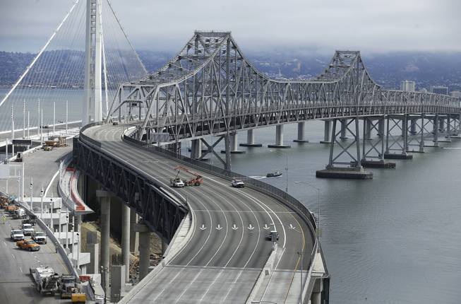 The self-anchored suspension of the new eastern section of the San Francisco-Oakland Bay Bridge is seen at left behind the current eastern section which is closed to traffic in San Francisco, Thursday, Aug. 29, 2013. Commuters faced their first morning on Thursday without the bridge, but there weren't major traffic snarls as day broke across the Bay Area. Alternate bridges to get into San Francisco were more crowded around 6:30 a.m., and Bay Area Rapid Transit trains appeared to be carrying a heavier load than usual. But commuters were managing to get around.