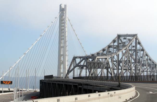 The old and the new come together at the approach to the tunnel at Yerba Buena Island on the third day of the Bay Bridge closure in Oakland, Calif., Friday, Aug. 30, 2013. When traffic flows across the new stretch of the San Francisco-Oakland Bay Bridge for the first time this week, it will do so nearly a quarter-century after a deadly earthquake during the 1989 World Series collapsed two 50-foot sections of the old structure. The 6.9-magnitude Loma Prieta quake hit just as millions tuned in to watch Game 3 of the Bay Bridge World Series between the Oakland Athletics and San Francisco Giants, killing 63 people and causing up to $10 billion in damage. The Bay Bridge failure, one of the temblors most memorable images, prompted one of the costliest public works projects in state history. The $6.4 billion project finally draws to a close after decades of political bickering, engineering challenges and billions in cost overruns.