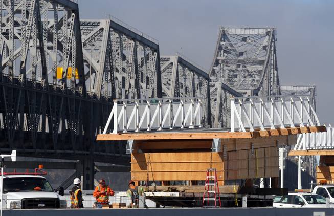 Pre-built sections of the bike bridge sit waiting to be installed on the third day of the Bay Bridge closure in Oakland, Calif., Friday, Aug. 30, 2013. When traffic flows across the new stretch of the San Francisco-Oakland Bay Bridge for the first time this week, it will do so nearly a quarter-century after a deadly earthquake during the 1989 World Series collapsed two 50-foot sections of the old structure. The 6.9-magnitude Loma Prieta quake hit just as millions tuned in to watch Game 3 of the Bay Bridge World Series between the Oakland Athletics and San Francisco Giants, killing 63 people and causing up to $10 billion in damage. The Bay Bridge failure, one of the temblors most memorable images, prompted one of the costliest public works projects in state history. The $6.4 billion project finally draws to a close after decades of political bickering, engineering challenges and billions in cost overruns.