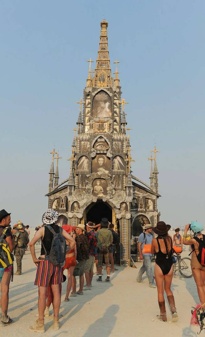 In this Wednesday, Aug. 28, 2013 photo, people gather at the "Photo Chapel" at Burning Man in Gerlach, Nev. Once a year, tens of thousands of participants gather for Burning Man in Nevada's Black Rock Desert to create Black Rock City, dedicated to community, art, self-expression and self-reliance.