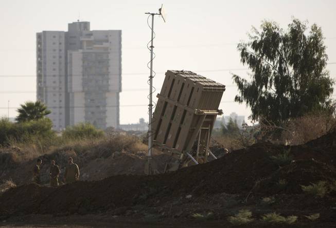 Israeli soldiers stand next to an Iron Dome battery, a short-range missile defense system, just outside Tel Aviv, Israel, Friday, Aug. 30, 2013. As the United States considers military action against Syria, Israel has deployed the Iron Dome missile defense system in central Israel.