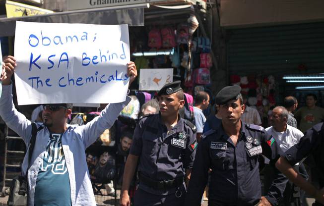 A Jordanian protester holds a placard that accuses Saudi Arabia of being the mastermind of a chemical attack in Syria, during a protest by the Jordanian Communist Party and other lefty groups against any American military strike against Damascus, in Amman, Jordan, Friday, Aug. 30, 2013.