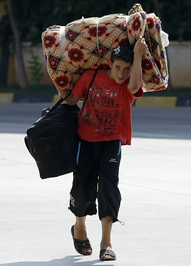 A Syrian boy carries his personal belongings as he passes through the Turkish Cilvegozu gate border with Syria, Friday, Aug. 30, 2013. United Nations experts are investigating the alleged use of chemical weapons in Syria as the United States and allies prepare for the possibility of a punitive strike against President Bashar Assad's regime, blamed by the Syrian opposition for the attack. The international aid group Doctors Without Borders says at least 355 people were killed in the Aug. 21 attack.