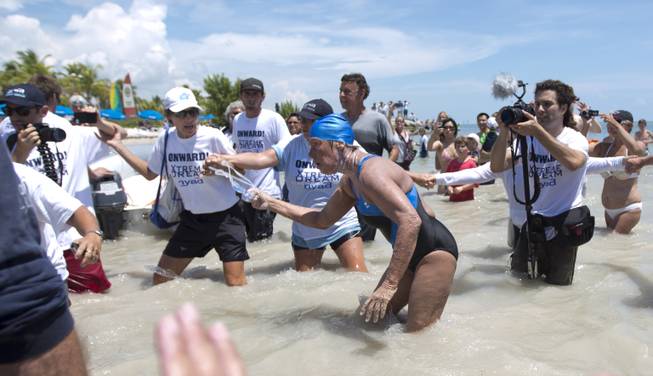 Diana Nyad struggles to come ashore in Key West, Fla., Monday, Sept. 2, 23013, after swimming from Cuba. Looking dazed and sunburned, U.S. endurance swimmer Diana Nyad walks ashores becoming the first person to swim from Cuba to Florida without the help of a shark cage. Nyad arrived at the beach just before 2 p.m. EDT, about 53 hours after she began her swim in Havana on Saturday.