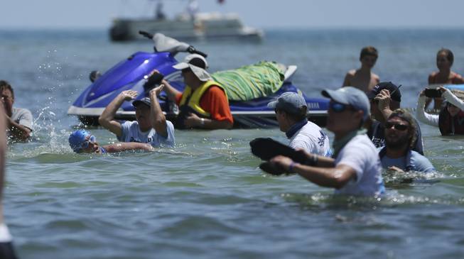 Fans urge Diana Nyad onto shore at Key West, Fla. Monday, Sept. 2, 2013. Looking dazed and sunburned, U.S. endurance swimmer Diana Nyad walks ashore becoming the first person to swim from Cuba to Florida without the help of a shark cage. Nyad arrived at the beach just before 2 p.m. EDT, about 53 hours after she began her swim in Havana on Saturday.