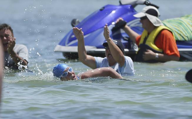 Long endurance swimmer Diana Nyad makes the last strokes to shore in Key West, Fla., Monday, Sept. 2, 2013, after swimming from Cuba. Looking dazed and sunburned, U.S. endurance swimmer Diana Nyad walked ashore Monday, becoming the first person to swim from Cuba to Florida without the help of a shark cage. Nyad arrived at the beach just before 2 p.m. EDT, about 53 hours after she began her swim in Havana on Saturday.
