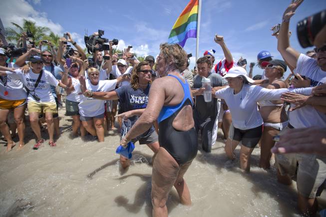 United States endurance swimmer Diana Nyad is greeted by a crowd as she walks on to the Key West, Fla., shore Monday, Sept. 2, 2013, becoming the first person to swim from Cuba to Florida without the help of a shark cage. Nyad arrived at the beach just before 2 p.m. EDT, about 53 hours after she began her swim in Havana on Saturday.