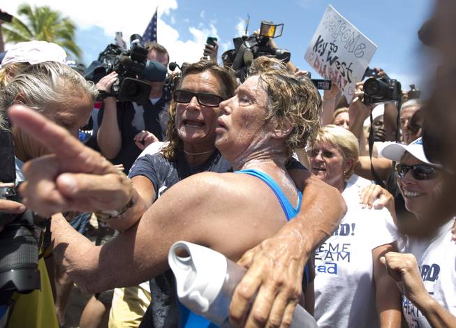 Endurance swimmer Diana Nyad, right, and her trainer, Bonnie Stoll hug after Nyad walks ashore Monday, Sept. 2, 2013, in Key West, Fla. after swimming from Cuba. Nyad became the first person to swim from Cuba to Florida without the help of a shark cage. She arrived at the beach just before 2 p.m. EDT, about 53 hours after she began her swim in Havana on Saturday.