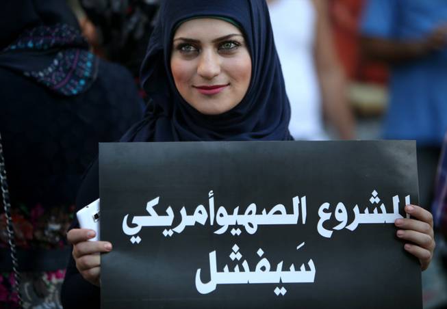 A Lebanese pro-Syrian regime supporter, holds a placard with Arabic that reads, "the Zionist-American project shall fail," during a demonstration against a possible military strike in Syria, near the U.S. Embassy in Aukar, east of Beirut, Lebanon, Friday, Sept. 6, 2013. The prospect of a U.S.-led strike against Syria has raised concerns of potential retaliation from the Assad regime or its allies. The State Department ordered nonessential U.S. diplomats to leave Lebanon over security concerns and urged private American citizens to depart as well.