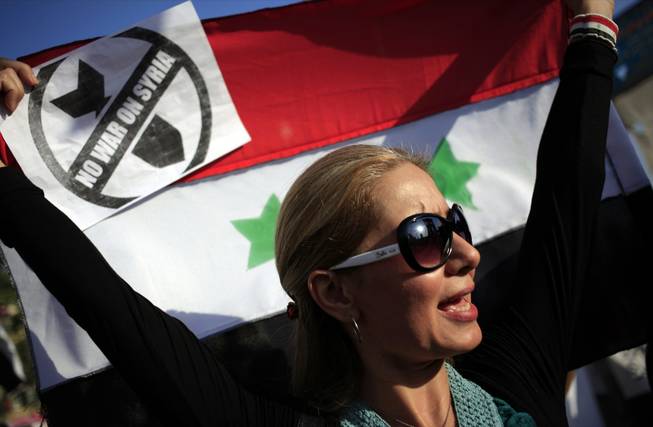 Demonstrators chant slogans against a possible U.S. military strike against Syria as holding Syrian flags during a protest in Cairo, Egypt, Monday, Sept. 9, 2013. The United States has been seeking international support for limited strikes against Assad's government, which it accuses of using chemical weapons in an Aug. 21 assault near the capital Damascus. President Barack Obama is also seeking authorization from Congress for the strikes. (AP Photo/Khalil Hamra)