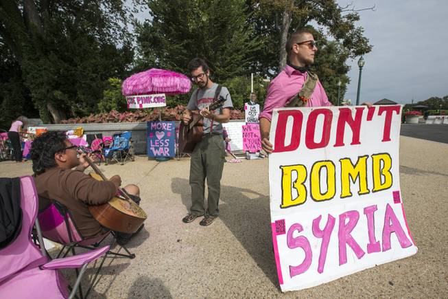 Peace activists opposed to American intervention in Syria, gather on a street corner at the U.S. Capitol in Washington, Monday, Sept. 9, 2013. As Congress returns to work from August recess, President Barack Obama is seeking authorization from Congress for a military strike against Syria in response to the use of chemical weapons in the civil war there.