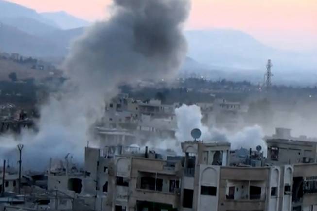 In this image taken from video obtained from the Shaam News Network, which has been authenticated based on its contents and other AP reporting, smoke rises from buildings due to heavy artillery shelling in Barzeh, a district of Damascus, Syria, Tuesday, Sept. 10, 2013.