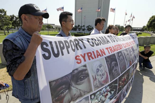Members of the Southern California Chinese-American community and others demonstrate in favor of a U.S. Senate resolution that would authorize President Barack Obama to use military force against the ruling regime in Syria, outside the federal building in the Westwood district of Los Angeles Tuesday, Sept. 10, 2013.