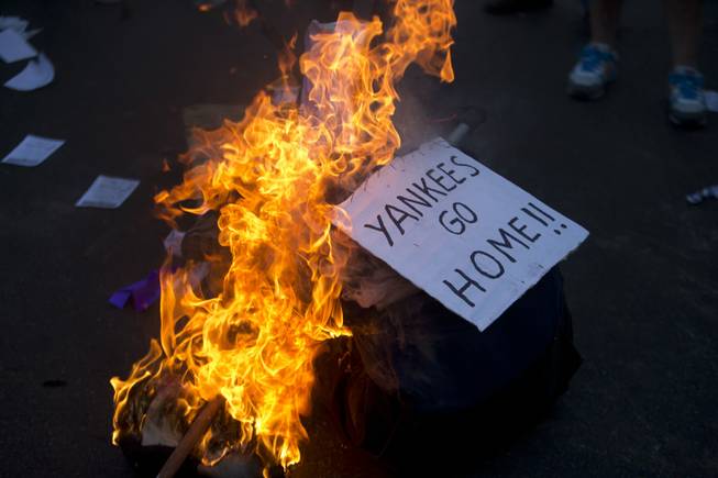 A sing is burns during a march against U.S. intervention in Syria in Buenos Aires, Argentina, Tuesday, Sept. 10, 2013. A Russian plan for Syria to turn over its chemical weapons to avert Western missile strikes bogged down Tuesday when Moscow rejected U.S. and French demands for a binding U.N. resolution with "very severe consequences" for non-compliance.(AP Photo/Victor R. Caivano)