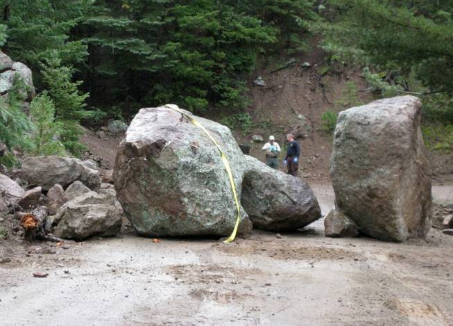 This photo released Wednesday Sept. 11, 2013 by Coconino County Sheriff's office shows investigators at the scene of a boulder slide where a Phoenix man was seriously injured while trying to move another boulder. The 27-year-old unidentified man was hospitalized for injuries to his legs and pelvis.