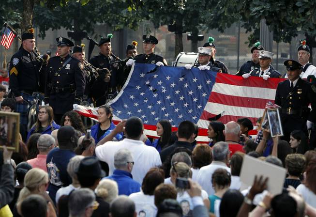 The World Trade Center Flag is presented as friends and relatives of the victims of the 9/11 terrorist attacks gather at the National September 11 Memorial at the World Trade Center site, Wednesday, Sept. 11, 2013, for a ceremony marking the 12th anniversary of the attacks in New York.