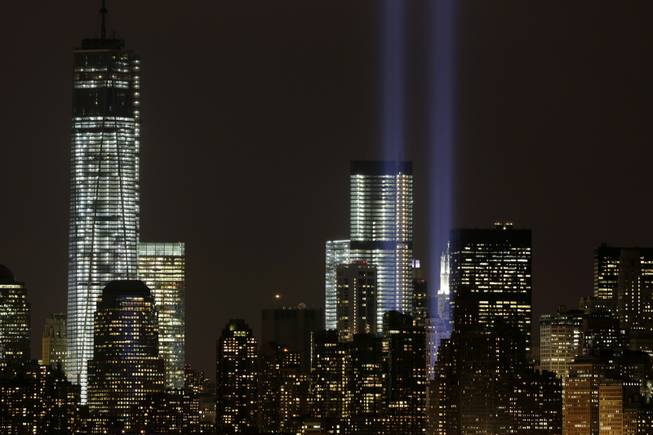 The Tribute in Light rises above the lower Manhattan skyline and Four World Trade Center, center, and One World Trade Center, left, in a test of the memorial light display, Monday, Sept. 9, 2013 in New York. The twin beams of light will also appear Wednesday, Sept. 11, twelve years after the terrorist attacks of Sept. 11, 2011.