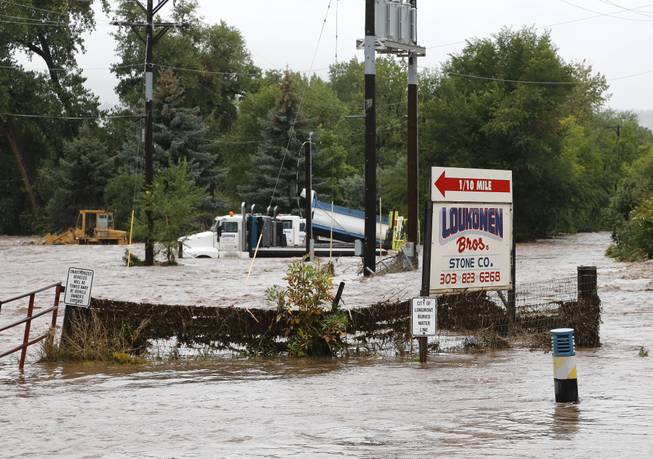 The overflowing St. Vrain River swamps structures following overnight flash flooding, one mile east of Lyons, Colo., Thursday, Sept. 12, 2013. At least three people are reported dead and the widespread high waters are keeping search and rescue teams from reaching stranded residents in Lyons and nearby mountain communities as heavy rains hammered northern Colorado.