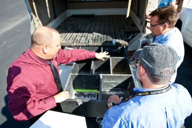 Rick Nelson (left), Land Rover event and social media director, identifies storage compartments in the 1997 Land Rover Defender to Mike Smith, from right, and Matt Hufman as they prepare to explore Nevada over the next year working on the Finding Nevada Project at the Land Rover Las Vegas dealership Friday, September 13, 2013.