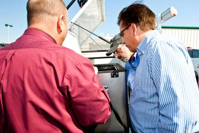 Las Vegas Sun cartoonist Mike Smith, from right, and reporter Matt Hufman investigate a built-in refrigerator in the back of the trailer of the 1997 Land Rover Defender they will drive exploring Nevada over the next year working on the Finding Nevada Project at the Land Rover Las Vegas dealership Friday, September 13, 2013.