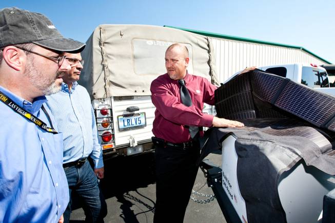 Rick Nelson (right), Land Rover event and social media director, explains the use of solar panels to be used by Matt Hufman, left, and Mike Smith in the 1997 Land Rover Defender they will drive exploring Nevada over the next year working on the Finding Nevada Project at the Land Rover Las Vegas dealership Friday, September 13, 2013.