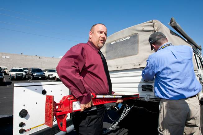 Rick Nelson (left), Land Rover event and social media director, prepares to load a vehicle jack inside the 1997 Land Rover Defender Matt Hufman, right, and Mike Smith, not shown, will drive exploring Nevada over the next year working on the Finding Nevada Project at the Land Rover Las Vegas dealership Friday, September 13, 2013.