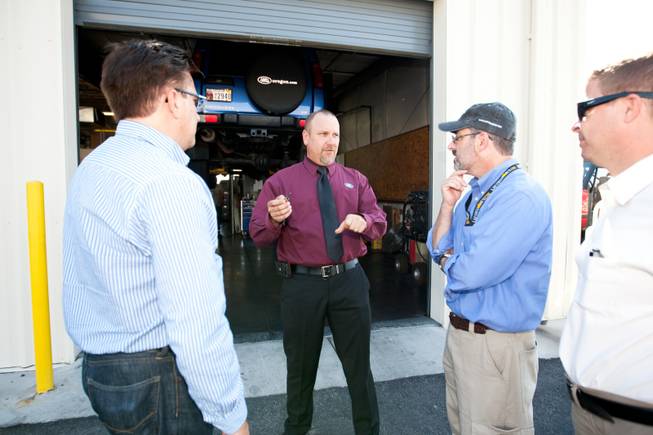 Rick Nelson (center), Land Rover event and social media director, hands over the keys of the 1997 Land Rover Defender to Mike Smith, from left, and Matt Hufman as they prepare to explore Nevada over the next year working on the Finding Nevada Project at the Land Rover Las Vegas dealership Friday, September 13, 2013. Las Vegas Sun Publisher Donn Jersey listens to the right.