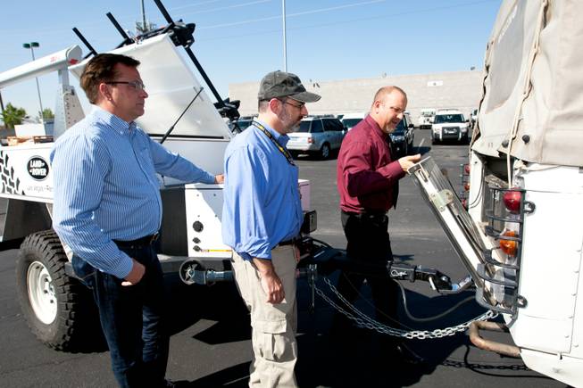 Rick Nelson (right), Land Rover event and social media director, demonstrates how to lower the hatch of the 1997 Land Rover Defender Mike Smith, from left, and Matt Hufman will drive as they explore Nevada over the next year working on the Finding Nevada Project at the Land Rover Las Vegas dealership Friday, September 13, 2013.