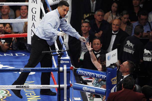 Referee Tony Weeks retrieves Danny Garcia's mouthguard during his fight against Lucas Matthysses Saturday, Sept. 14, 2013 at the MGM Grand Garden Arena.