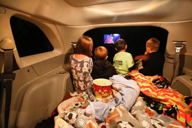 (Left to right) Coy Erickson 5, her friend Quin Petty, 4, brother Gunnar Erickson, 7, and friend Owen Petty, 7, watch the movie, "Monsters University" from inside a SUV parked at the American Dream drive-in theater in Powell, Wyoming, on September 14, 2013. This is Wyoming's first and last remaining drive-in theater. (Mel Melcon/Los Angeles Times/MCT)