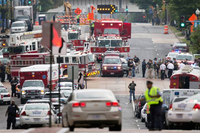 Emergency personnel respond to a reported shooting at the Washington Navy Yard, Monday, Sept. 16, 2013 in Washington. Police and federal agents from multiple law enforcement agencies responded to the scene. Ambulances were parked outside, streets in the area were closed and departures from Reagan National Airport were temporarily halted for security reasons.
