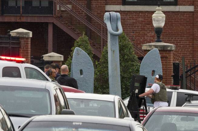 Police bring in equipment by an anchor outside of an entrance to the Washington Navy Yard where a gunman was reported in Washington, on Monday, Sept. 16, 2013. The exact number of people killed and the conditions of those wounded was not immediately known. About 3,000 people work at the Naval Sea Systems Command headquarters.