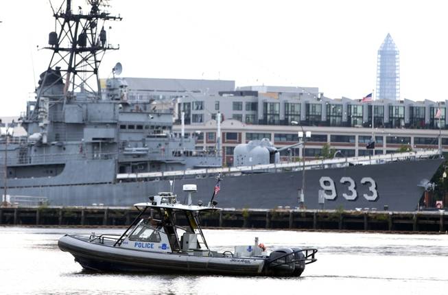 A police boat patrols near the scene of a shooting at the Washington Navy Yard on Monday, Sept. 16, 2013, in Washington. At least one gunman opened fire inside a building at the Washington Navy Yard, and officials said six people were killed and as many as 10 were wounded, including a law enforcement officer.